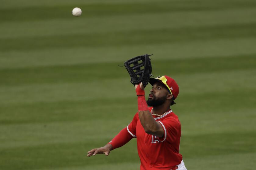 Los Angeles Angels center fielder Jo Adell catches a fly ball for the out hit into by Texas Rangers' Jeff Mathis during the fifth inning of a spring training baseball game Friday, Feb. 28, 2020, in Tempe, Ariz. (AP Photo/Charlie Riedel)