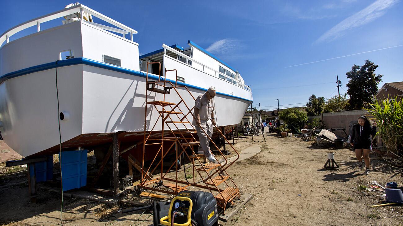 Dillon Griffith climbs down from the boat he has spent decades building. He hopes to finally get it into the ocean this summer.