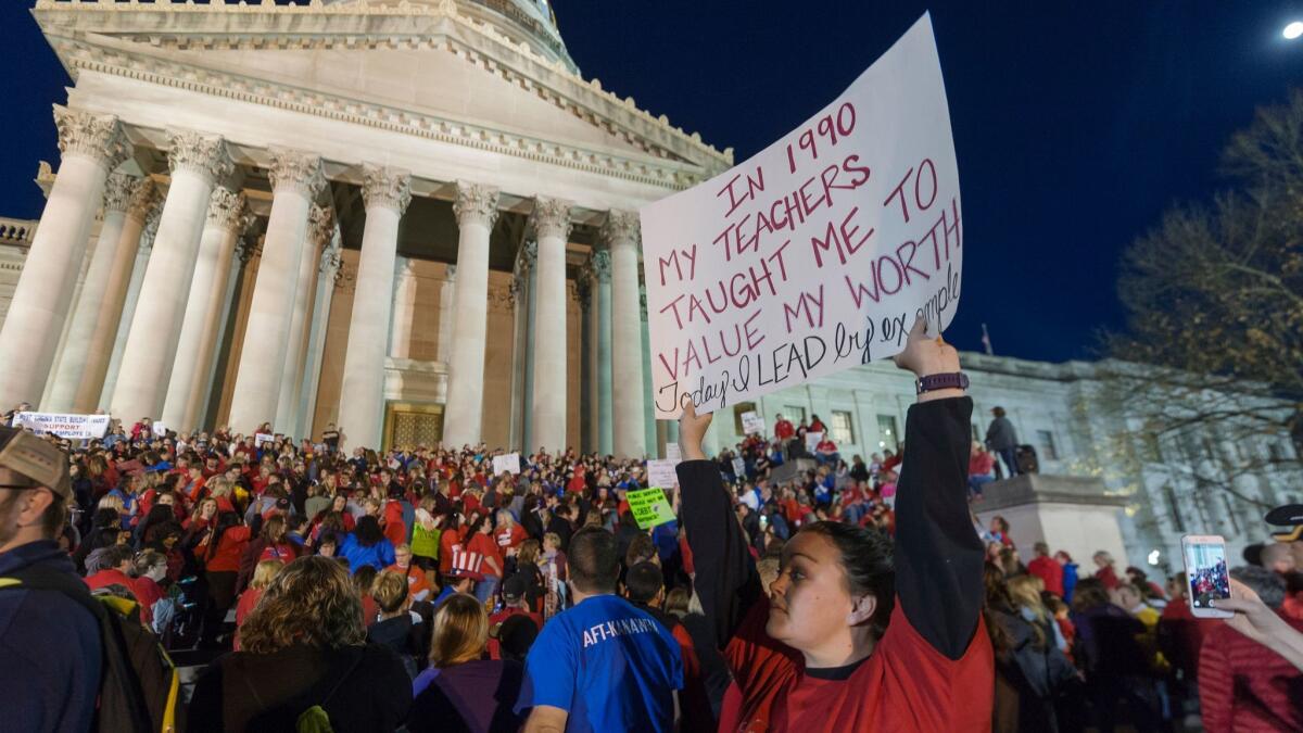 Jennyerin Steele Staats, a special education teacher from Jackson County, holds a protest sign during rally at the West Virginia Capitol on March 2, 2018.