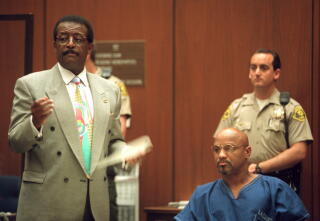 Former Black Panther Elmer 'Geronimo' Pratt sitting in court next to attorney Johnnie Cochran, who is standing