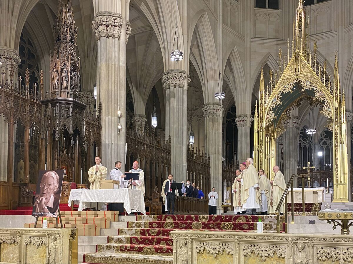 Cardinal Timothy Dolan, center left, presides over the sealing of cardboard boxes filled with evidence of Dorothy Day’s “reputation for holiness” during a Mass at St. Patrick’s Cathedral in New York, Dec. 8, 2021. The boxes will be sent to the Congregation for the Causes of Saints in Rome. (Renée Roden/RNS via AP)