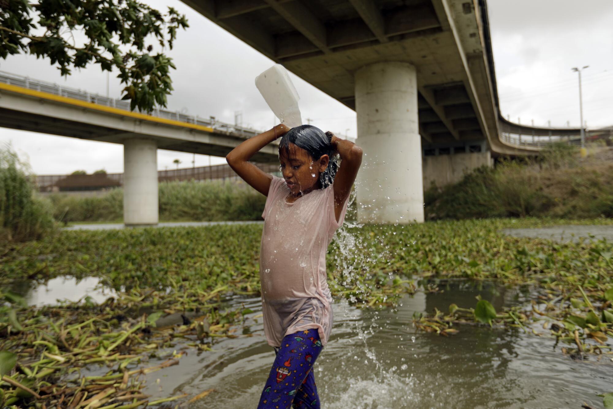 A migrant girl washes her hair.