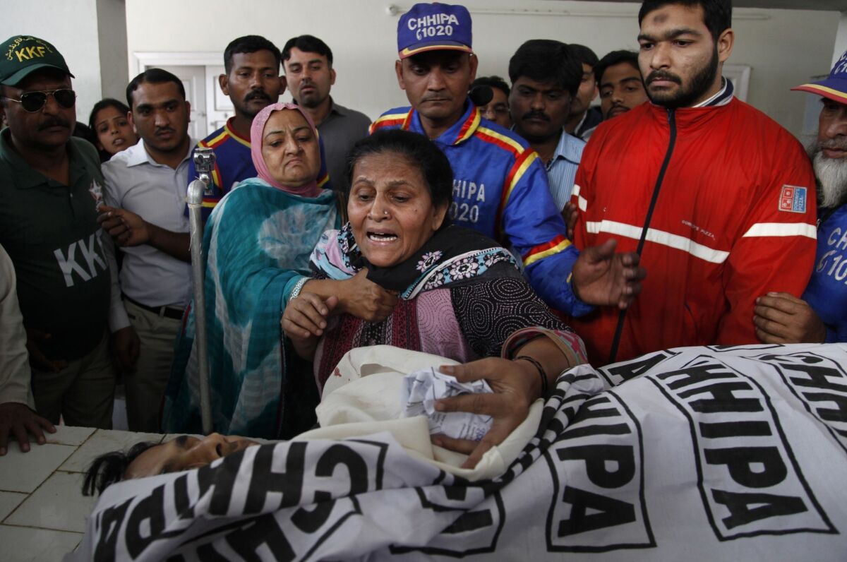 A Pakistani woman grieves over the body of her son, a polio worker who was killed by unknown gunmen in Karachi.