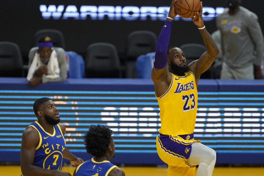 Los Angeles Lakers forward LeBron James (23) dunks in front of Golden State Warriors forward Eric Paschall (7) and center James Wiseman during the first half of an NBA basketball game in San Francisco, Monday, March 15, 2021. (AP Photo/Jeff Chiu)