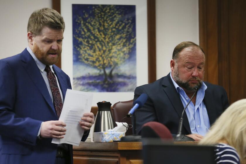 Mark Bankston, lawyer for Neil Heslin and Scarlett Lewis, asks Alex Jones questions about text messages during trial at the Travis County Courthouse in Austin, Wednesday Aug. 3, 2022. Jones testified Wednesday that he now understands it was irresponsible of him to declare the Sandy Hook Elementary School massacre a hoax and that he now believes it was “100% real." (Briana Sanchez/Austin American-Statesman via AP, Pool)