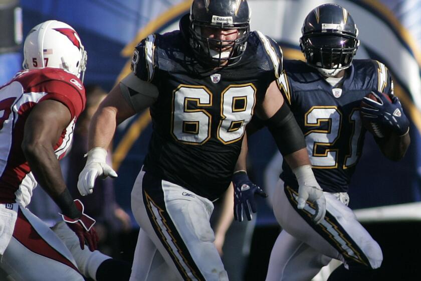 Chargers running back LaDainian Tomlinson follows the blocking of teammate Kris Dielman during a game at Qualcomm Stadium in December 2006.