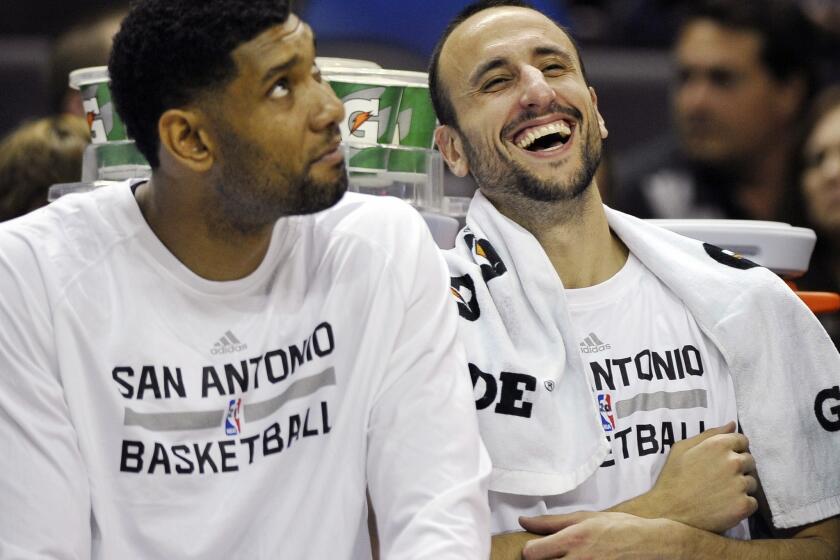 San Antonio Spurs teammates Tim Duncan, left, and Manu Ginobili share a light-hearted moment on the bench during a preseason game on Oct. 13.