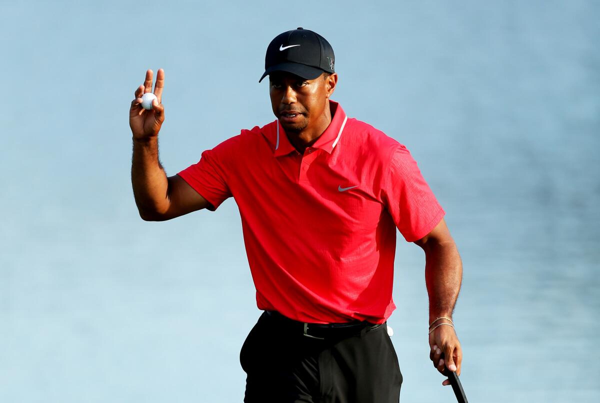 Tiger Woods waves to the crowd after finishing on the 18th green during the final round of the Players Championship.