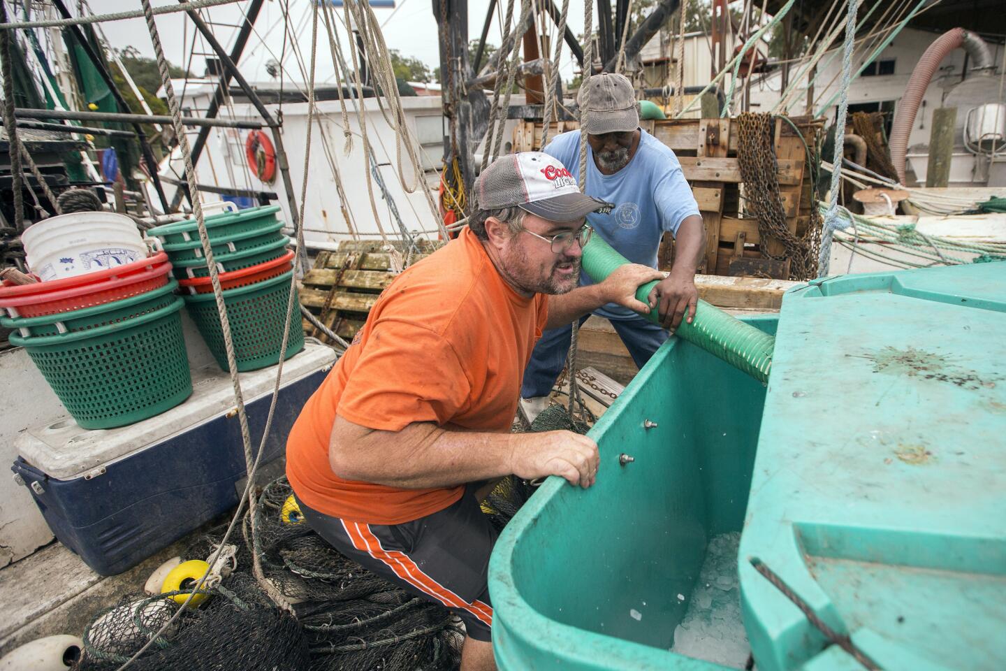 Shrimp boat Captain Wynn Gale, left, and Earnest White, right, fill a ice box with 900 pounds of ice during storm preparations for Hurricane Matthew, Thursday, Oct. 6, 2016, in Darien, Ga. Hurricane Matthew steamed toward Florida with terrifying winds of 140 mph Thursday, and 2 million people across the Southeast were warned to flee inland. (AP Photo/Stephen B. Morton)