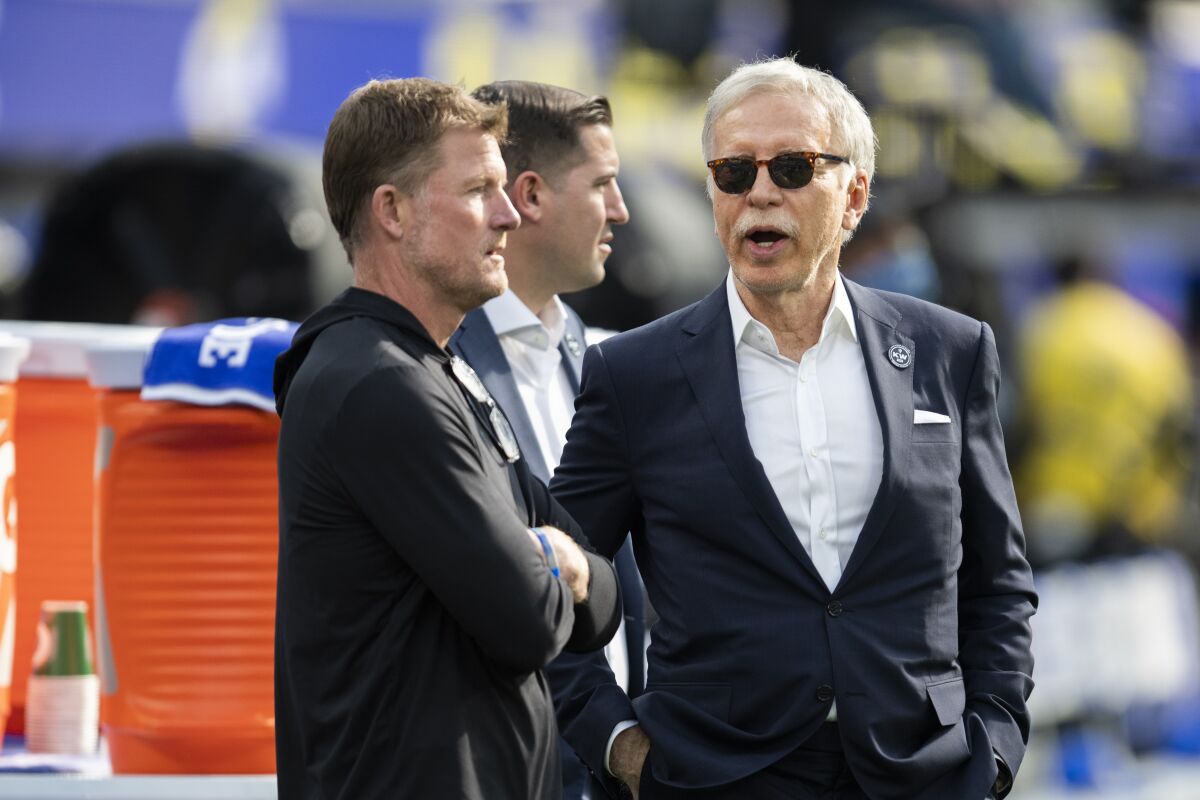 Rams owner Stan Kroenke talks to general manager Les Snead before a game.