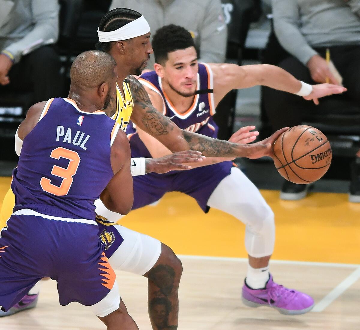 Lakers guard Kentavious Caldwell-Pope makes a steal between Suns guards Chris Paul and Devin Booker.