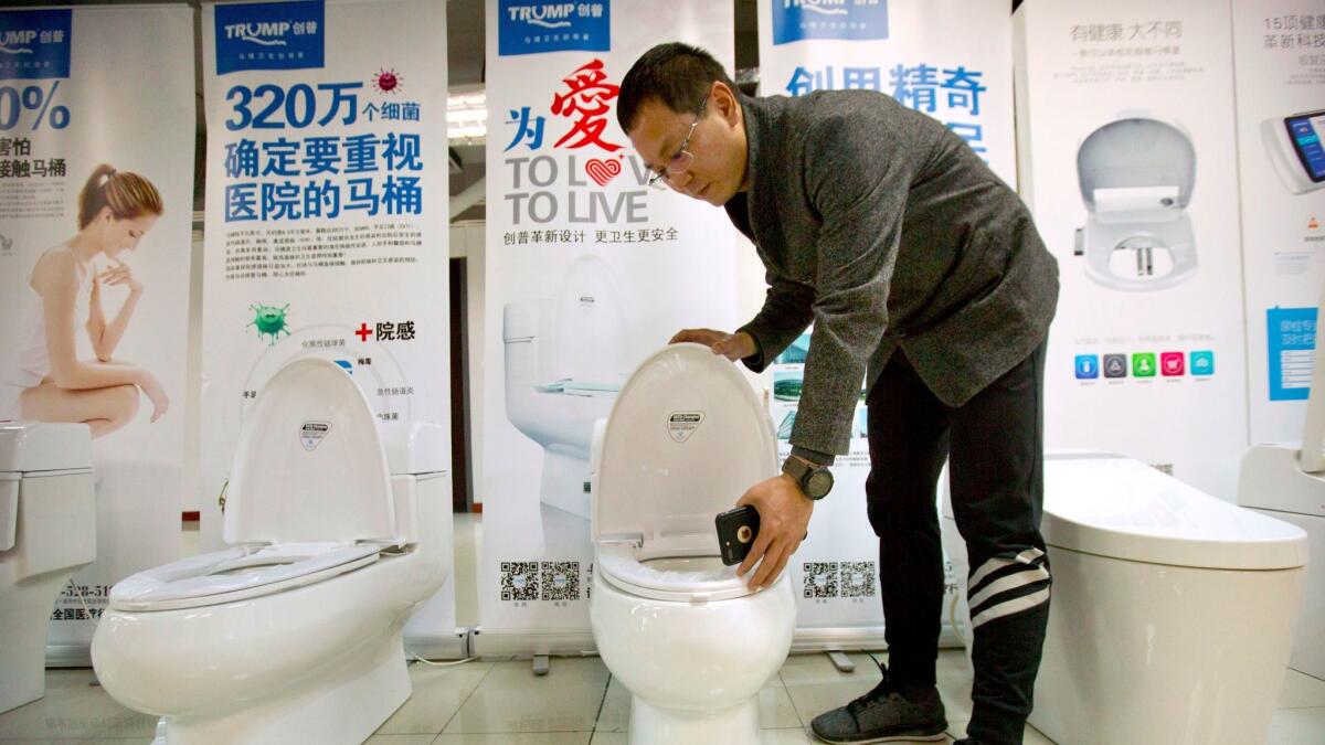 Zhong Jiye, co-founder of Shenzhen Trump Industrial Co., demonstrates one of his firm's high-end Trump-branded toilets at a showroom in Shenzhen in southern China on Feb. 13, 2017.