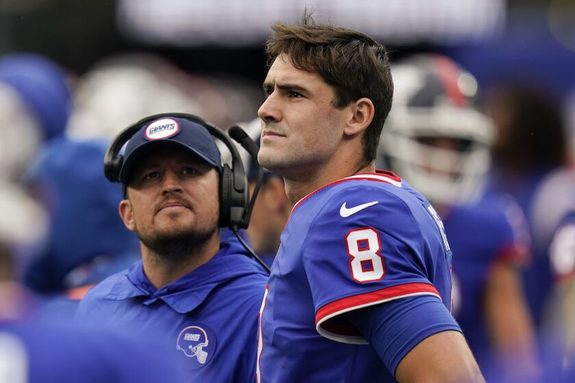 New York Giants quarterback Daniel Jones (8) watches play from the sidelines after coming out of the game during the fourth quarter of an NFL football game against the Chicago Bears, Sunday, Oct. 2, 2022, in East Rutherford, N.J. (AP Photo/Seth Wenig)