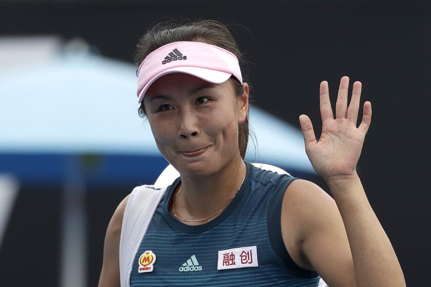 FILE - China's Peng Shuai waves after losing to Canada Eugenie Bouchard in their first round match at the Australian Open tennis championships in Melbourne, Australia on Jan. 15, 2019. Out of public view for almost three weeks, Chinese tennis player Peng Shuai appeared Sunday, Nov. 21, 2021 in a live video call with International Olympic Committee President Thomas Bach. (AP Photo/Mark Schiefelbein, File)