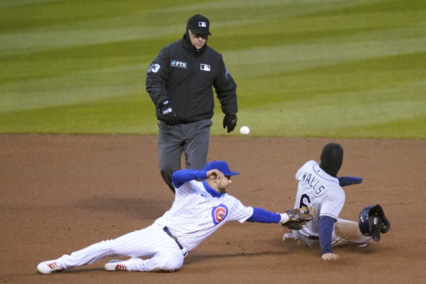 Second base umpire Todd Tichenor watches as Tampa Bay Rays' Taylor Walls (6) steals second while Chicago Cubs' Nick Madrigal is unable to handle the throw from catcher Yan Gomes during the fourth inning of a baseball game Wednesday, April 20, 2022, in Chicago. (AP Photo/Charles Rex Arbogast)