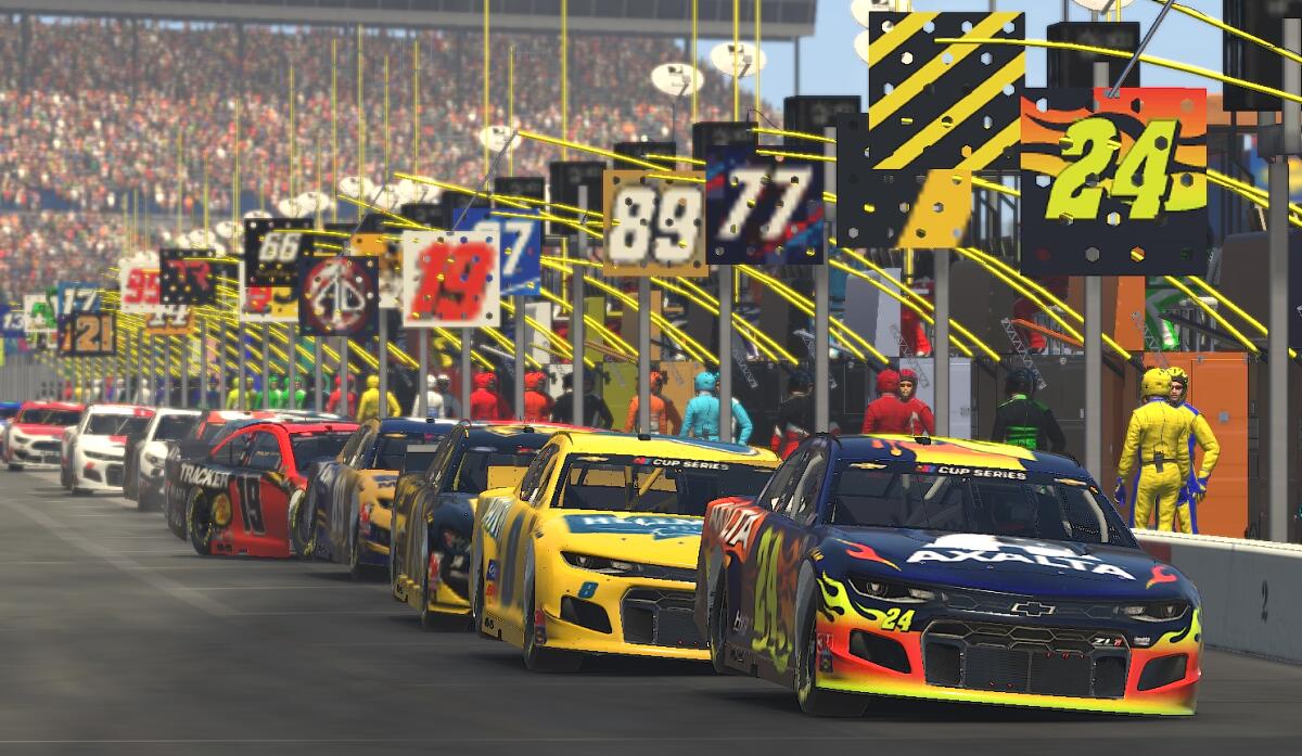 A view looking down pit row of cars being serviced during an eNASCAR iRacing event.