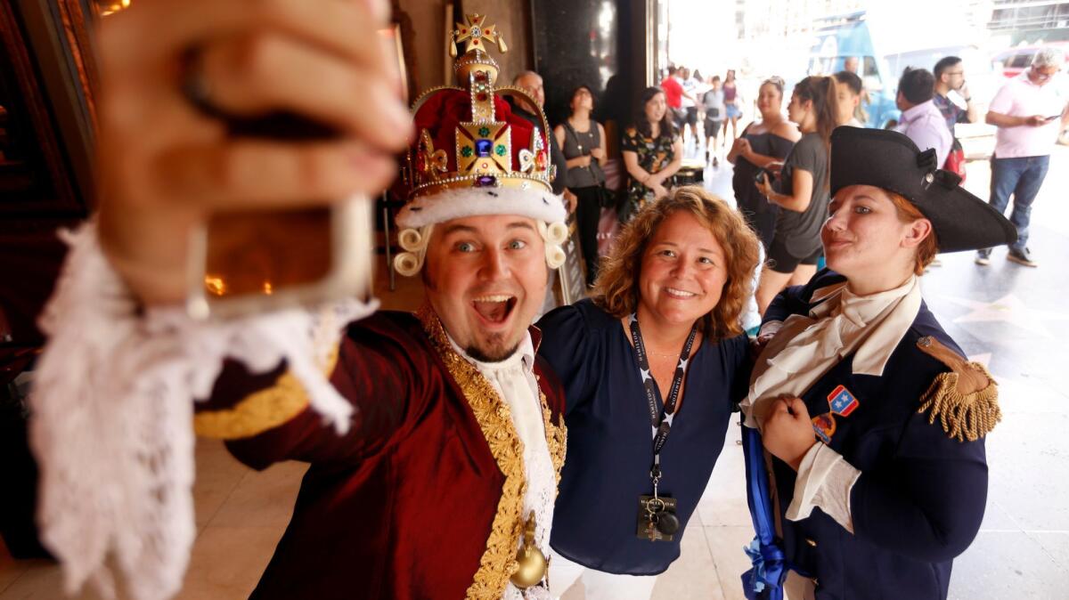 Chad Evett as King George III and Katie Aiani as George Washington take a selfie with Olivia Kimbley before the performance of "Hamilton" on Friday at the Pantages Theatre.