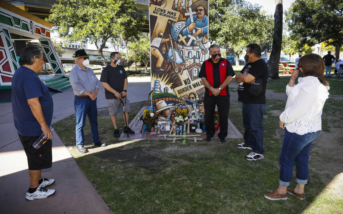 Friends stand at a memorial for Antonio Chavez Camarillo at Chicano Park in San Diego.