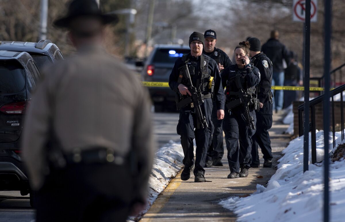 Several police officers are shown securing the scene of a shooting at Bridgewater College.