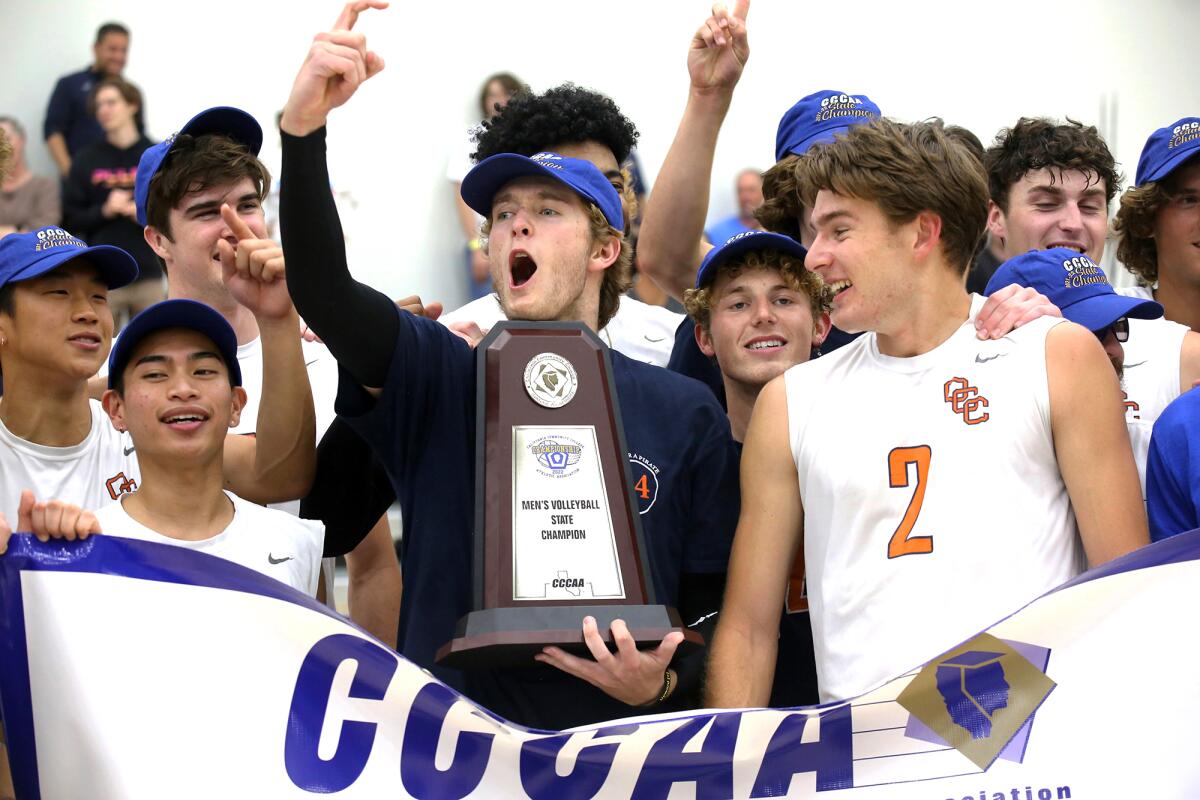 The Orange Coast College men's volleyball team celebrates after winning the CCCAA state championship against Long Beach.