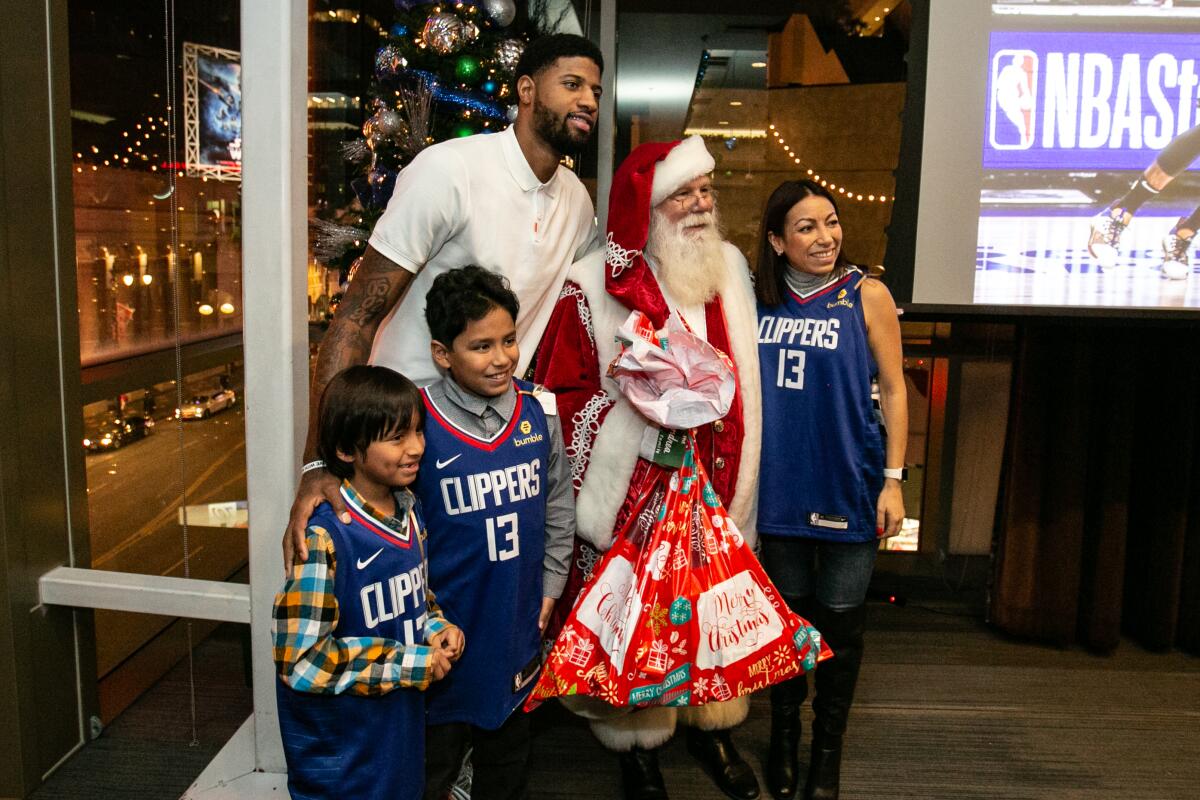 Paul George and Santa take a photo with the Paez family.