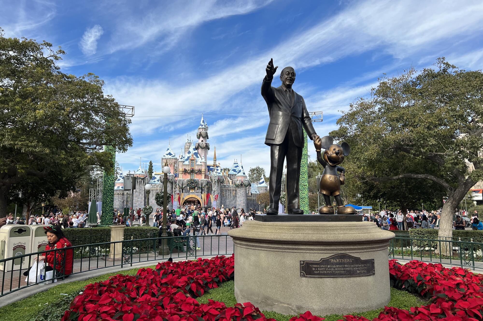 Al fondo, una vista del castillo de Disneyland que es decorado con miles de luces