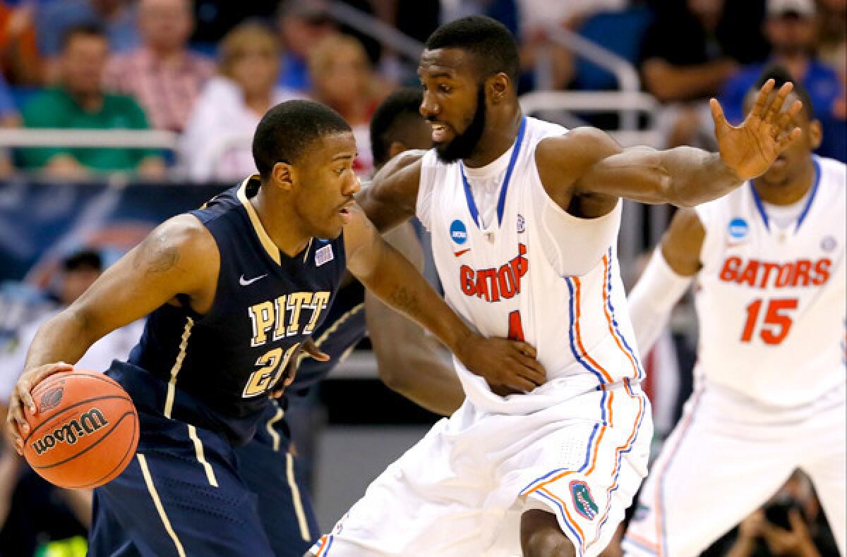 Florida center Patric Young plays bigger and more athletic than his 6-foot-9 frame. Here he cuts off a drive by Pittsburgh guard Lamar Patterson during a third-round game in the NCAA tournament on Saturday.