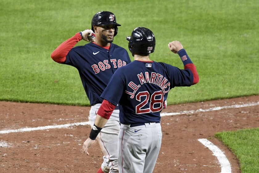 Boston Red Sox's Xander Bogaerts celebrates with teammate J.D. Martinez (28) after hitting a two-run home run against the Baltimore Orioles in the sixth inning of a baseball game, Saturday, May 8, 2021, in Baltimore. (AP Photo/Will Newton)