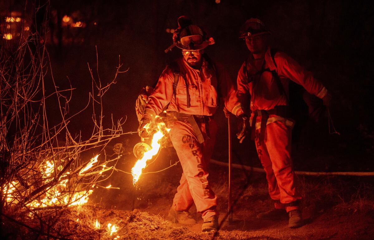 A firefighter uses a drip torch to slow the Fawn fire in Shasta County last month.