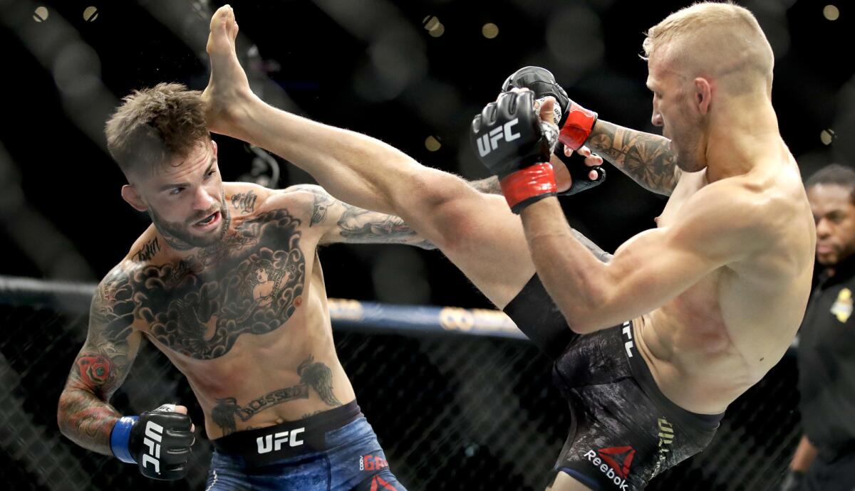 T.J. Dillashaw lands a kick against Cody Garbrandt during their UFC bantamweight title fight at UFC 227 on Aug. 4.