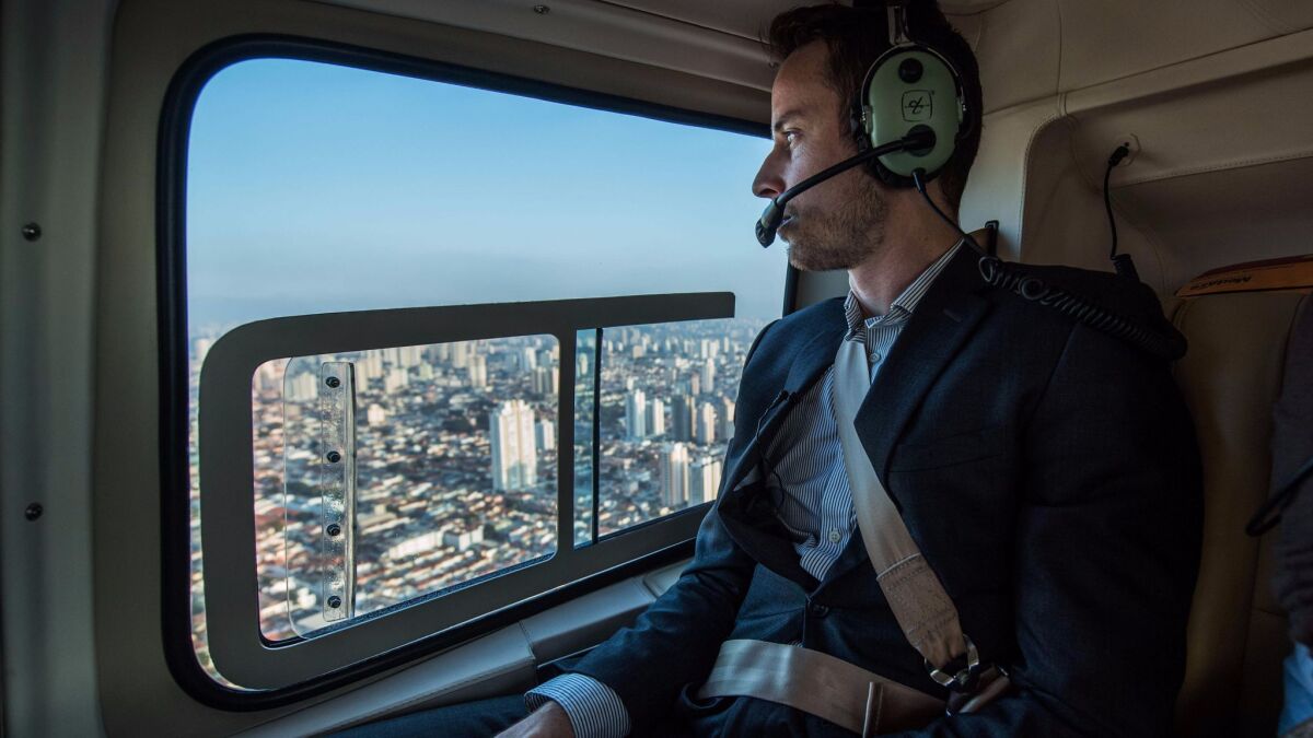 A Brazilian businessman flies over São Paulo, Brazil. Helicopter services offer an alternative to São Paulo's heavy car traffic. Could air taxis be developed to operate like Uber rides?
