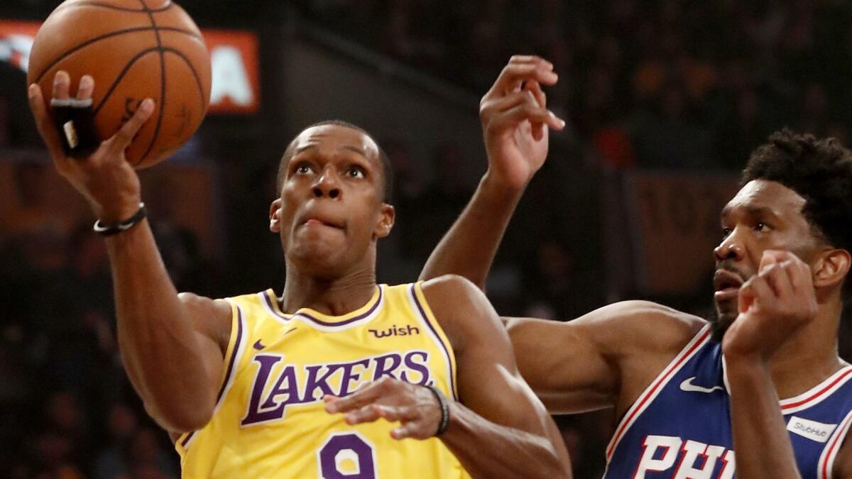 Lakers guard Rajon Rondo drives to the basket against 76ers forward Joel Embiid.