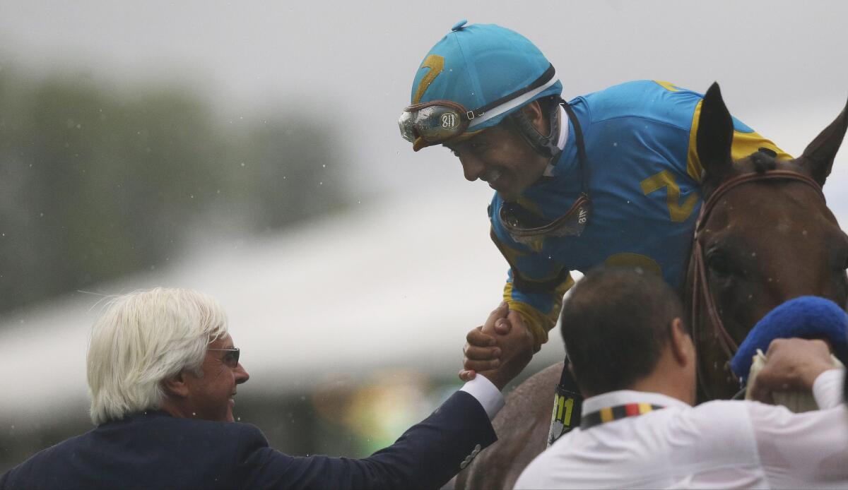 Trainer Bob Baffert congratulates jockey Victor Espinoza after he guided American Pharoah to victory in the 140th Preakness Stakes. The two live and work out of Southern California.