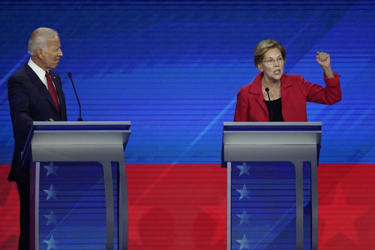 Former Vice President Joe Biden, left, listens as Sen. Elizabeth Warren, right, speaks during Thursday's debate.