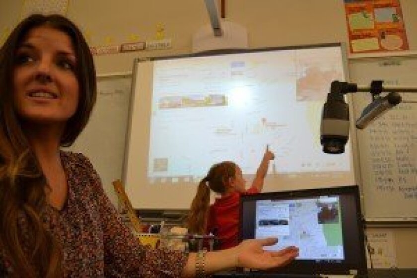 A student points out a location projected from the Skype screen.