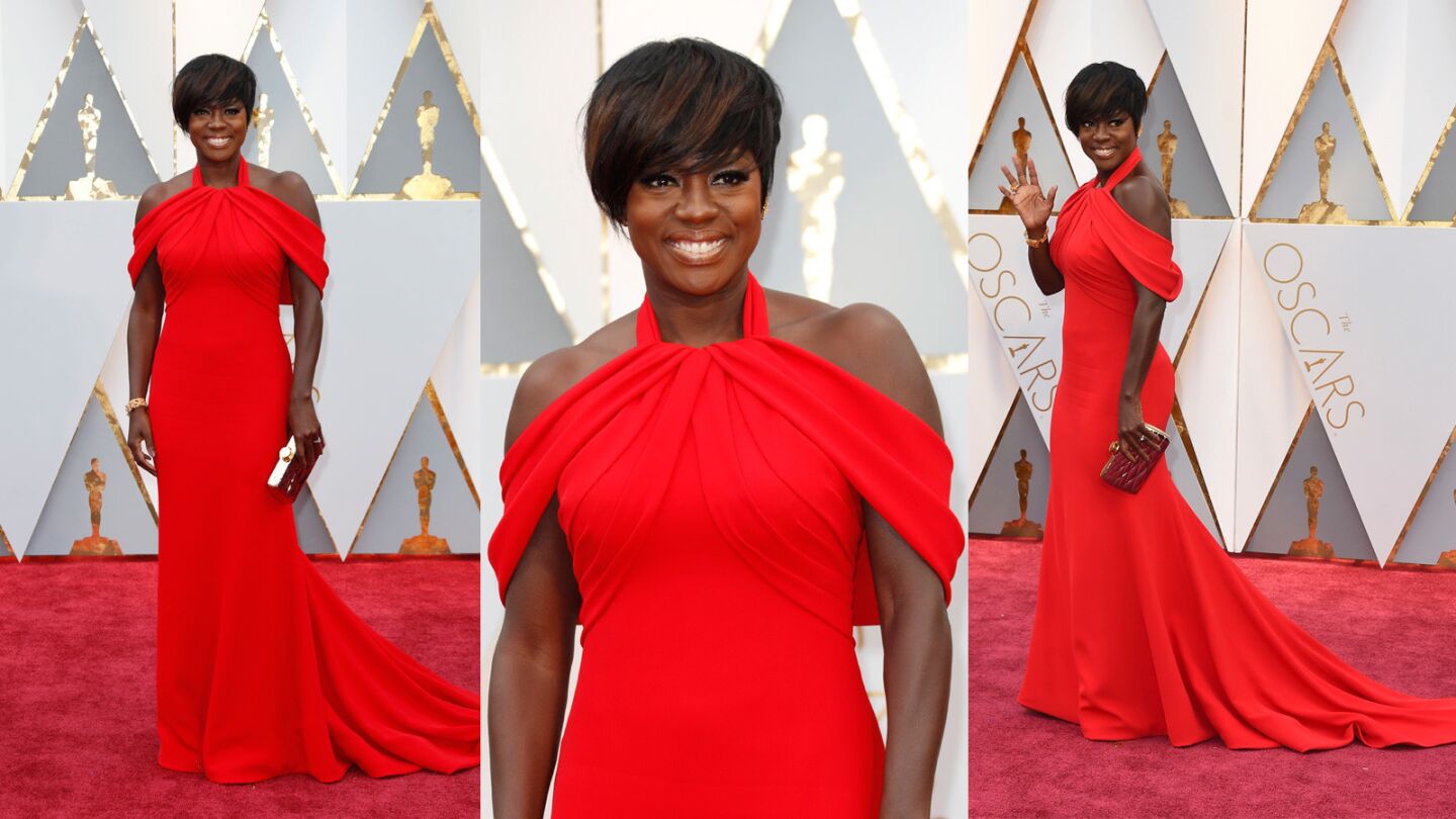 Viola Davis looks fierce in a custom red Armani Privé vermillion silk gown with a high neckline that falls into draped shoulders and pleated detailing on the bodice. In our opinion, Viola blazed her way onto the best-dressed list.