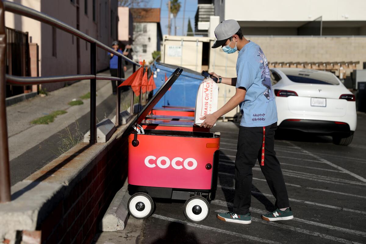 Aaron Joaquin, employee, places an order of Main Chick Hot Chicken to be delivered by a Coco robot