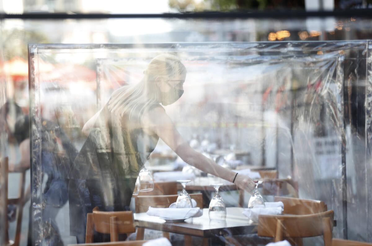 Lindsey Burkett sets a table at the Butcher's Cut Steakhouse outdoor seating area