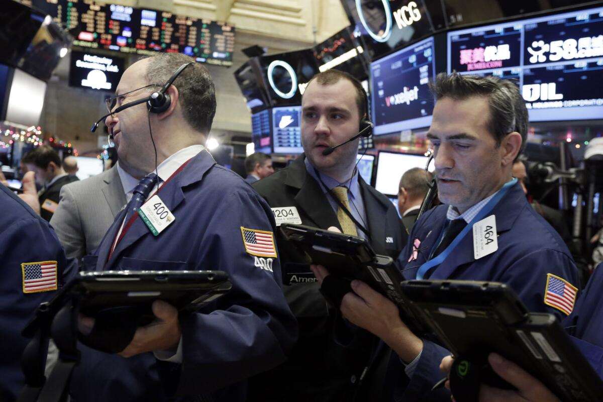 Traders Gordon Charlop, Nathan Wisniewski and Gregory Rowe work on the floor of the New York Stock Exchange.