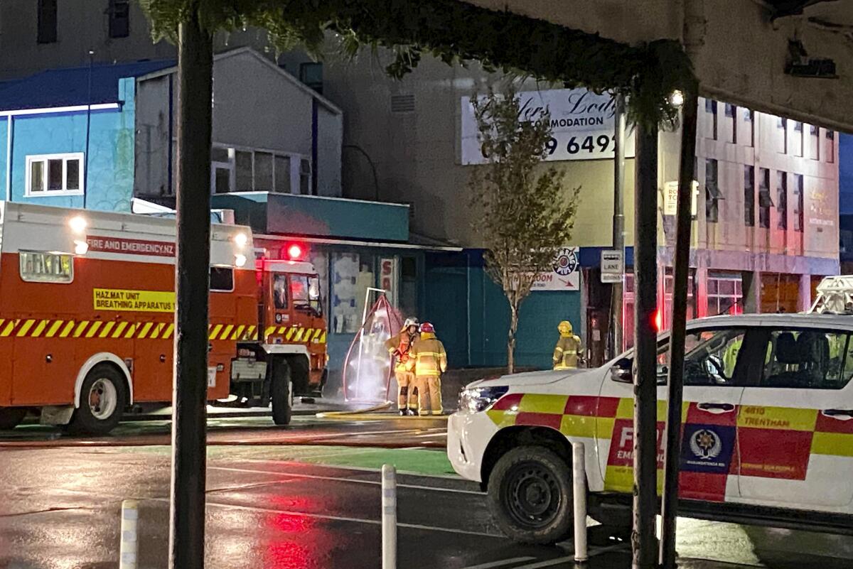 Firefighters outside a hostel hit by arson in Wellington, New Zealand
