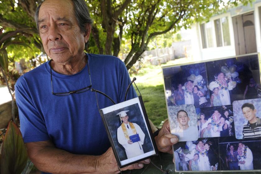 FILE - In this Monday, July 10, 2017 file photo, Clifford Kang, father of soldier Ikaika E. Kang, poses with photos of his son in Kailua, Hawaii. An indictment accuses Sgt. 1st Class Ikaika Kang of attempting to provide material support to the Islamic State group. Court records show that Kang is scheduled to withdraw his not guilty plea on Thursday, Aug. 23, 2018. (Bruce Asato/Honolulu Star-Advertiser via AP)