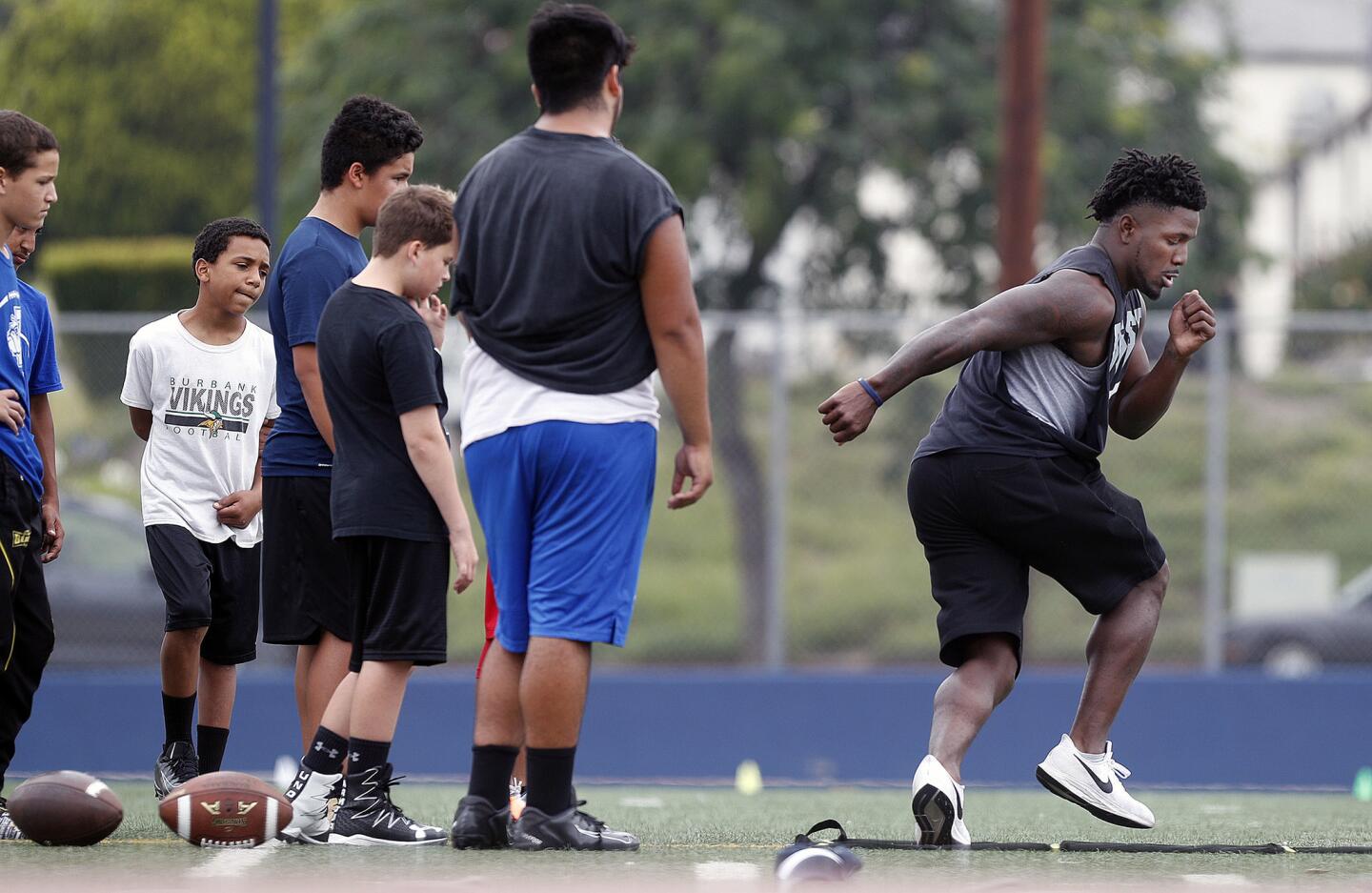 Camp leader James Williams demonstrates an agility exercise on the fitness latter to his campers at the inaugural Burbank High School football camp featuring former Bulldog running back and NFL hopeful James Williams on Wednesday, June 26, 2019.