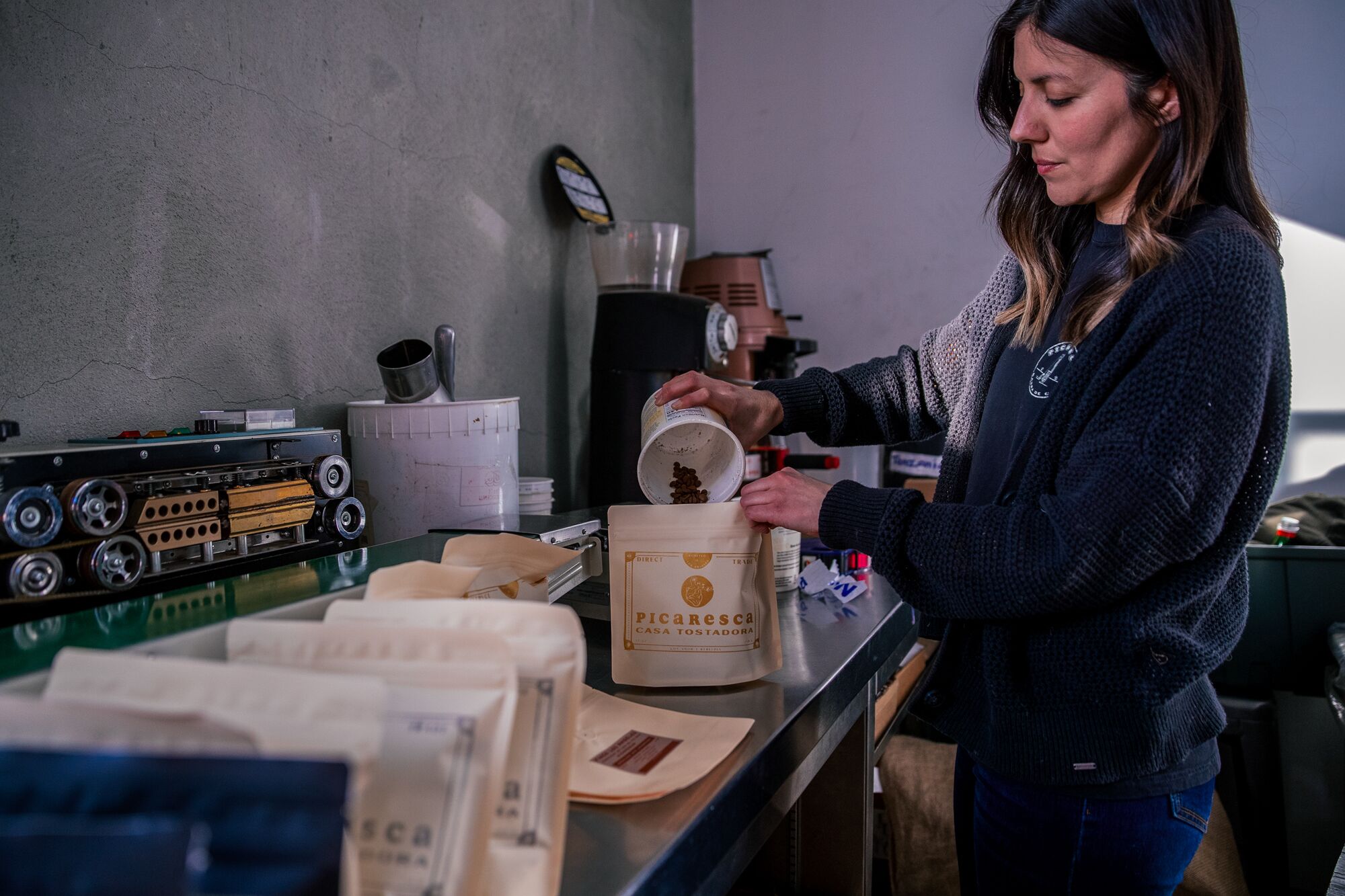 Picaresca Coffee'nin ortak sahibi Elisa Hoyos, Los Angeles şehir merkezindeki Cognoscenti'de kahve çekirdeklerini paketliyor.