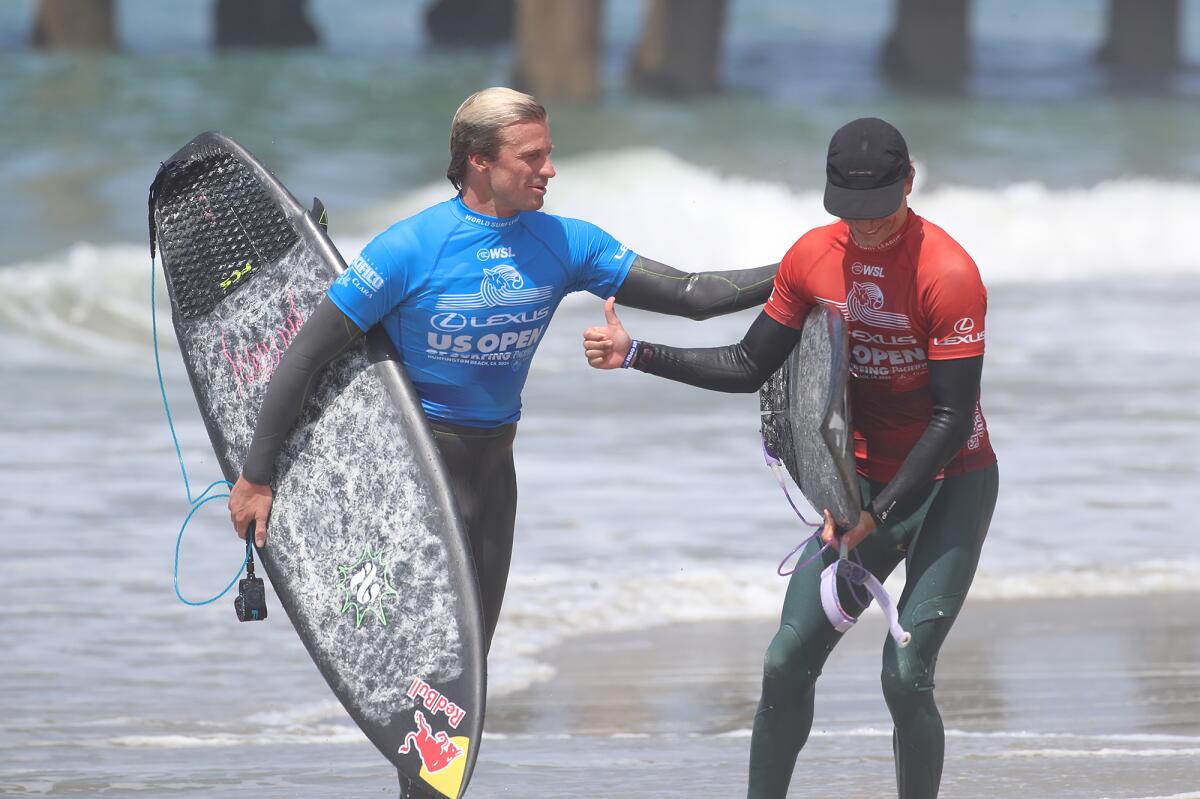 Kolohe Andino of San Clemente, left, greets fellow competitor Heitor Mueller after their heat on Wednesday.