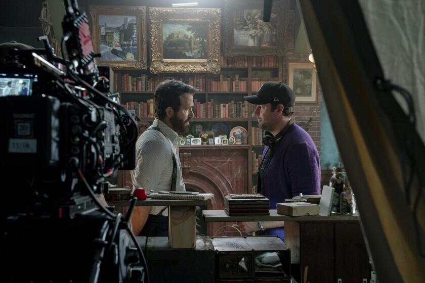 This image released by Paramount Pictures shows Ryan Reynolds, left, with director John Krasinski on the set of "IF." (Jonny Cournoyer/Paramount Pictures via AP)