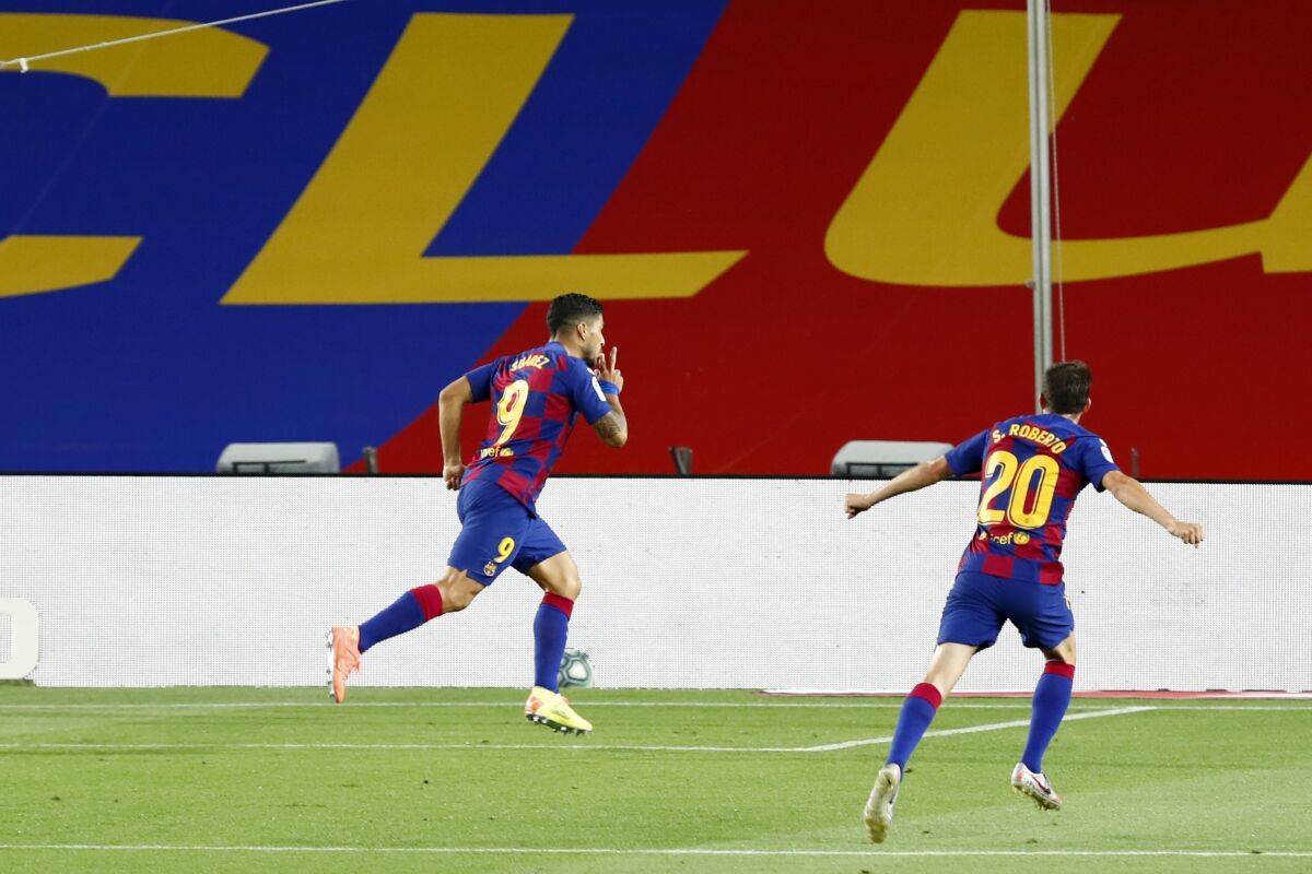 Barcelona's Luis Suarez celebrates scoring the opening goal during the Spanish La Liga soccer match between FC Barcelona and RCD Espanyol at the Camp Nou stadium in Barcelona, Spain, Wednesday, July 8, 2020. (AP Photo/Joan Monfort)