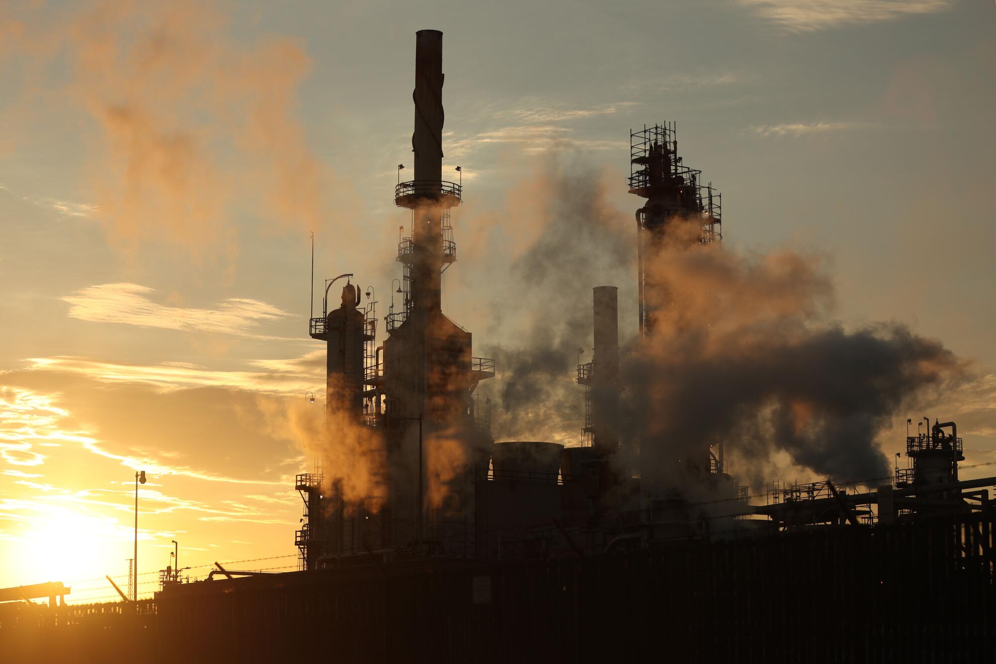  A view of a smoke-spewing refinery at sunset