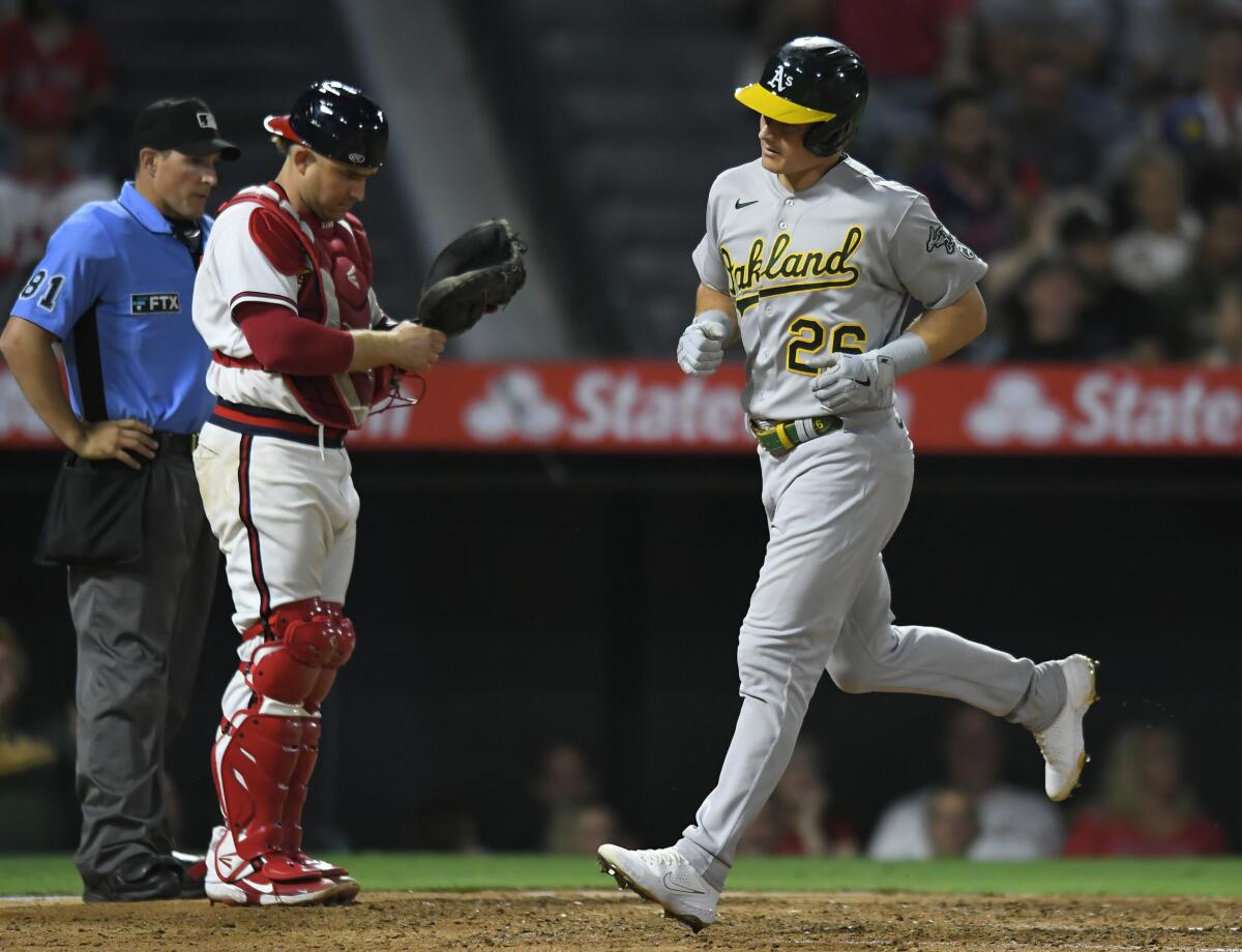 The Athletics' Matt Chapman crosses the plate in front of Angels catcher Max Stassi after homering in the eighth inning.
