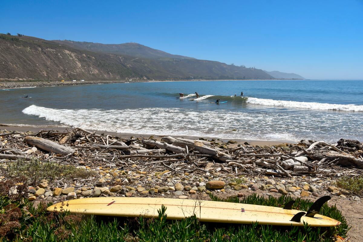 A surfboard on the beach in front of the ocean