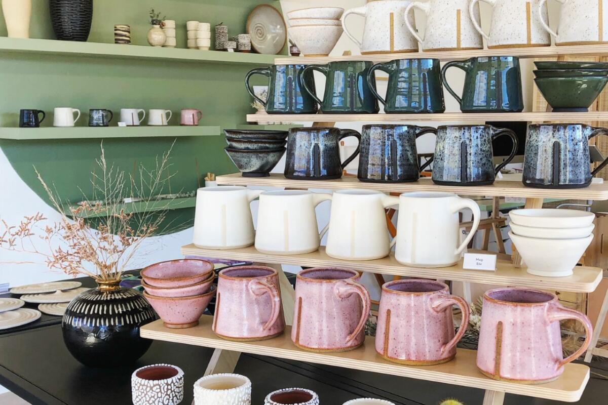 Ceramic mugs and vases displayed on shelves